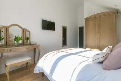 a bedroom with a bed and a desk with a mirror at Sea Vista in Carbis Bay