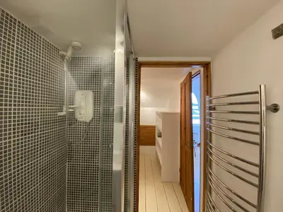 a bathroom with a walk in shower and a glass door at Frobisher Apartments in Falmouth