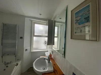 a bathroom with a sink and a mirror at Frobisher Apartments in Falmouth