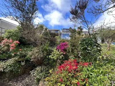 a garden of flowers in front of a building at Frobisher Apartments in Falmouth