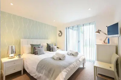a bedroom with a large bed with towels on it at Halcyon Cove in Carbis Bay