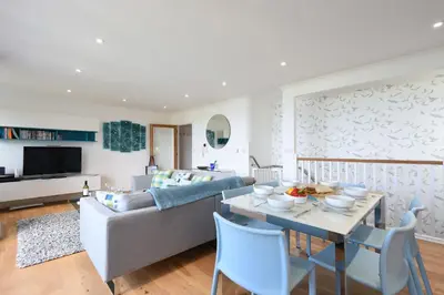 a living room with a couch and a table at Halcyon Cove in Carbis Bay
