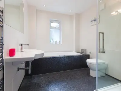 a bathroom with a tub and a sink and a toilet at Shamal in Carbis Bay