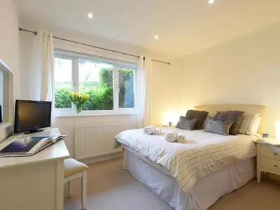 a bedroom with a bed and a desk and a computer at Shamal in Carbis Bay