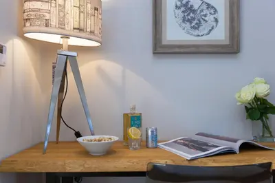 a desk with a lamp and a book and a bowl at The Oyster in St Ives