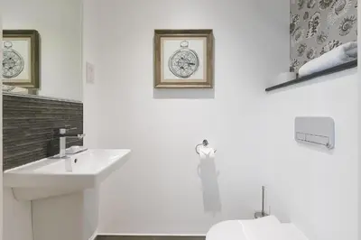 a white bathroom with a sink and a toilet at The Oyster in St Ives