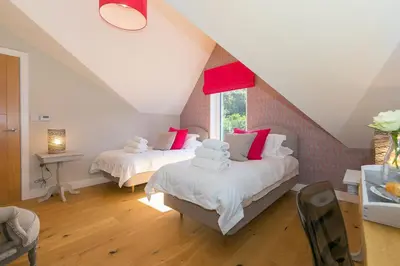 a attic bedroom with two beds and a window at The Oyster in St Ives
