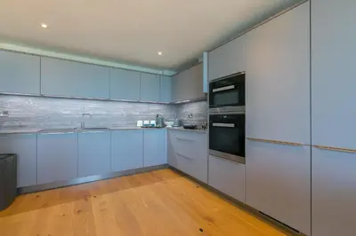 a kitchen with blue cabinets and stainless steel appliances at The Oyster in St Ives