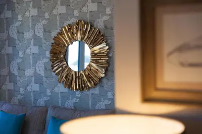 a mirror hanging on a wall next to a couch at The Oyster in St Ives