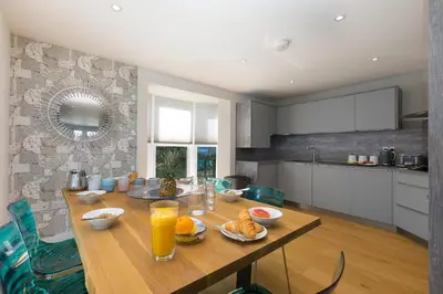 a kitchen with a wooden table with food on it at The Pearl in St Ives
