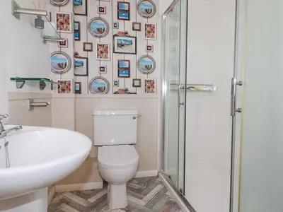 a bathroom with a toilet and a sink and a shower at 2 Old Talbot Cottages in Lostwithiel