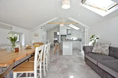 a kitchen and living room with a table and a couch at Charming Cottage, Wi-Fi, Parking, Pets Accepted in Newquay