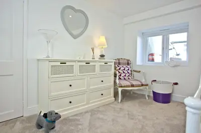 a white dresser in a white room with a mirror at Charming Cottage, Wi-Fi, Parking, Pets Accepted in Newquay