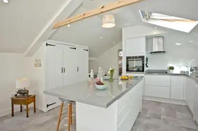 a kitchen with white cabinets and a counter top at Charming Cottage, Wi-Fi, Parking, Pets Accepted in Newquay