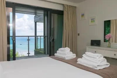 a bedroom with a bed with a view of the ocean at Waters Edge in St Ives
