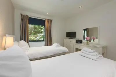 two white beds in a room with a window at Waters Edge in St Ives