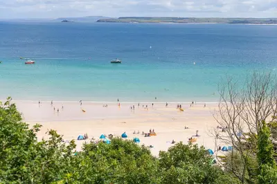 a group of people on a beach with the ocean at Waters Edge in St Ives