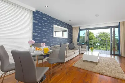 a living room with a couch and a table at Waters Edge in St Ives
