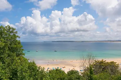 a beach with a bunch of people in the water at Waters Edge in St Ives