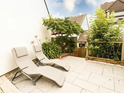 two white chairs are sitting on a patio at Padstowgetaways in Padstow