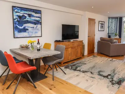 a living room with a table and chairs and a television at The View in St Ives