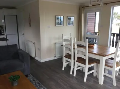 a kitchen and dining room with a table and chairs at Marios Lodge in Padstow