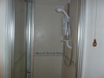 a shower with a shower head in a bathroom at Grey Mullet Guesthouse in St Ives