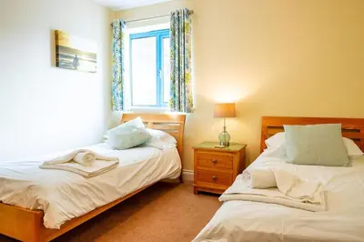 a bedroom with two beds and a window at Bay Retreat - Widemouth Bay Bude Cornwall in Bude