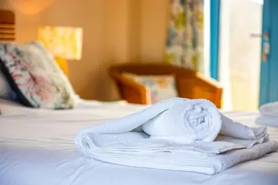 a pile of towels sitting on top of a bed at Bay Retreat - Widemouth Bay Bude Cornwall in Bude