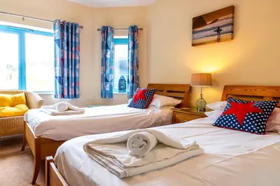 a bedroom with two beds with towels on them at Bay Retreat - Widemouth Bay Bude Cornwall in Bude