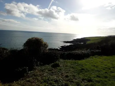 a view of the ocean from a grassy hill at Driftwood B&B in Porthscatho
