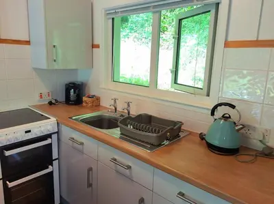 a kitchen counter with a sink and a stove at Kiberick Cottage at Crackington Haven, near Bude and Boscastle, Cornwall in Bude