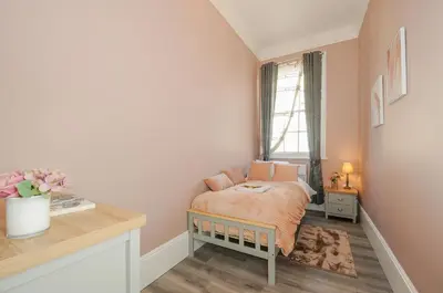 a small bedroom with a bed and a window at The Stannary in Helston