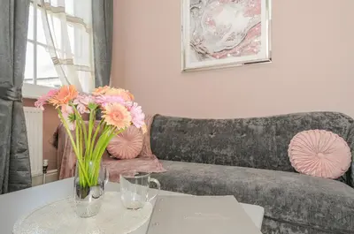 a living room with a couch and a table with flowers at The Stannary in Helston