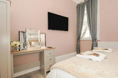 a bedroom with a bed with a mirror and a dresser at The Stannary in Helston