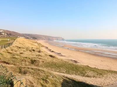a beach with a fence and the ocean at The Stannary in Helston