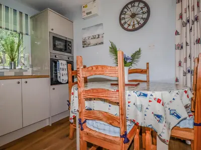 a kitchen and dining room with a table and chairs at Woodside in Liskeard