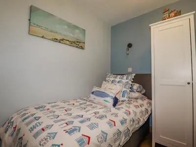 a bedroom with a bed and a painting on the wall at Woodside in Liskeard