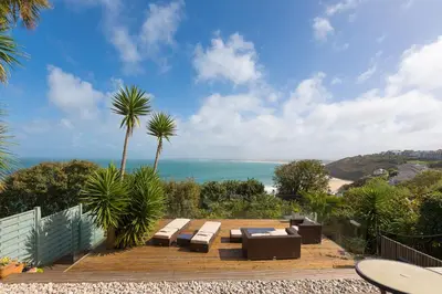a patio with benches and a view of the ocean at The Breakers in Carbis Bay