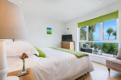 a bedroom with a white bed and a window at The Breakers in Carbis Bay