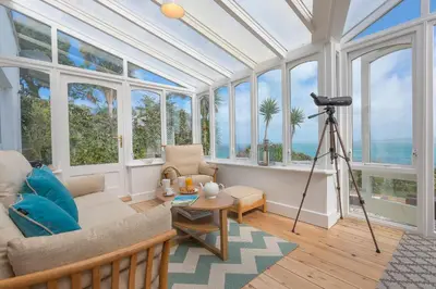 a living room with windows and a view of the ocean at The Breakers in Carbis Bay