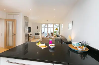 a kitchen and living room with a black counter top at The Breakers in Carbis Bay