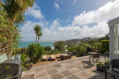 a patio with a view of the ocean at The Breakers in Carbis Bay