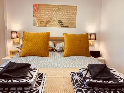 a bedroom with a bed with two yellow pillows at SHINE CHALET - UNIQUE & COMFORTABLE ACCOMMODATION in Redruth