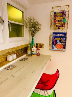 a kitchen with a wooden table with a vase of flowers at SHINE CHALET - UNIQUE & COMFORTABLE ACCOMMODATION in Redruth