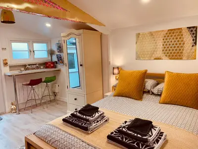 a bedroom with a bed with two towels on it at SHINE CHALET - UNIQUE & COMFORTABLE ACCOMMODATION in Redruth