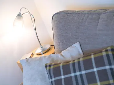 a lamp sitting on a table next to a couch at Laurellie in Carbis Bay