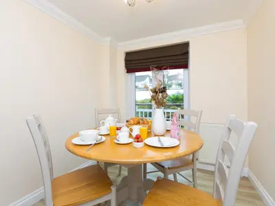 a dining room with a wooden table and chairs at Laurellie in Carbis Bay