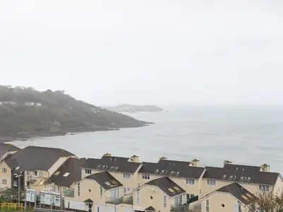 a row of houses next to a body of water at Laurellie in Carbis Bay