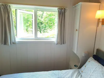 a bedroom with a bed and a window at Parada Cottage at Crackington Haven, near Bude and Boscastle, Cornwall in Bude
